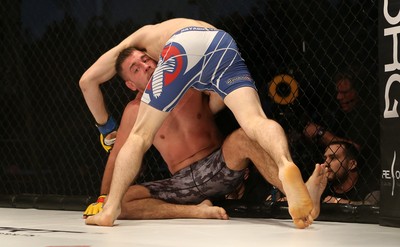 081218 - Cage Warriors 100 - Wales' Kris Edwards (grey shorts) v Aidan Stephen (blue and white shorts) during their Featherweight fight