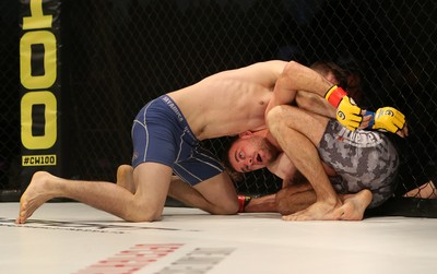 081218 - Cage Warriors 100 - Wales' Kris Edwards (grey shorts) v Aidan Stephen (blue and white shorts) during their Featherweight fight