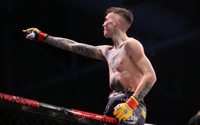 081218 - Cage Warriors 100 - Rhys McKee celebrates with coaches after victory over Jefferson George