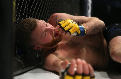 081218 - Cage Warriors 100 - Tim Barnett (Black shorts) lies on the ground after being defeated by Alex Lohore