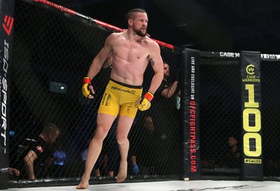 081218 - Cage Warriors 100 - Nicolas Dalby (Yellow shorts) celebrates winning over Philip Mulpeter (blue shorts) 