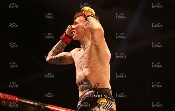 081218 - Cage Warriors 100 - Rhys McKee celebrates with coaches after victory over Jefferson George