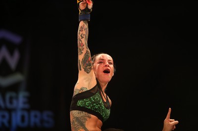 290918 - Cage Warriors 97 - Cory McKenna (Black Top) v Micol DiSegni (Green) - DiSiegni celebrates the win