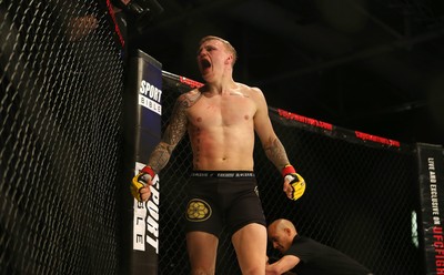 290918 - Cage Warriors 97 - Pontypool's Mason Jones (Black shorts) v Kasper Formela (Red shorts) - Jones celebrates the victory