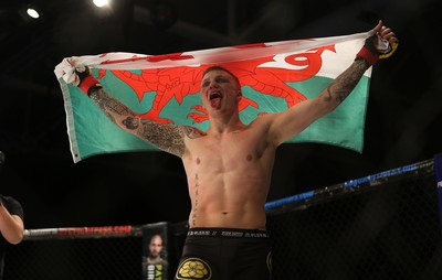 290918 - Cage Warriors 97 - Pontypool's Mason Jones (Black shorts) v Kasper Formela (Red shorts) - Jones celebrates with the flag