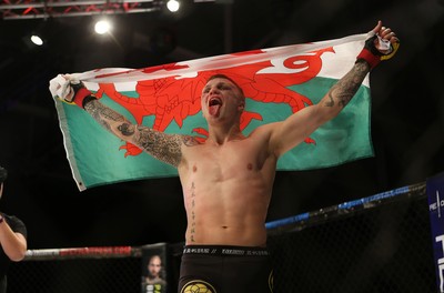 290918 - Cage Warriors 97 - Pontypool's Mason Jones (Black shorts) v Kasper Formela (Red shorts) - Jones celebrates with the flag