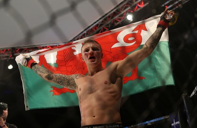 290918 - Cage Warriors 97 - Pontypool's Mason Jones (Black shorts) v Kasper Formela (Red shorts) - Jones celebrates with the flag