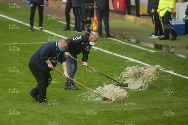 101020 - Cambridge United v Newport County - Sky Bet League 2 - Grounds men sweep the waterlogged areas of the pitch at half time