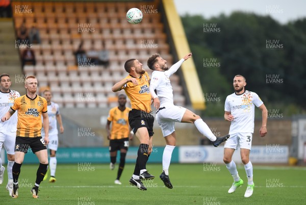 140818 - Cambridge United v Newport County - EFL Cup - Gary Deegan of Cambridge United and Josh Sheehan of Newport County compete for high ball