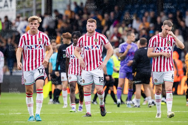 300825 - Cambridge United v Newport County - Sky Bet League 2 - Newport County’s Tom Davies, Newport County’s Lee Jenkins and Newport County’s Ciaran Brennan dejected after their sides defeat 