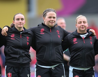 300825 - Canada v Wales, Women’s Rugby World Cup - Left to right, Nel Metcalfe, Maisie Davies and Molly Reardon of Wales line up for the anthems