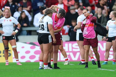 300825 - Canada v Wales, Women’s Rugby World Cup - Jenni Scoble of Wales receives treatment from Dr Gwennan Williams, Wales Women team doctor, and Cara Jones, physio before leaving the pitch with an injury