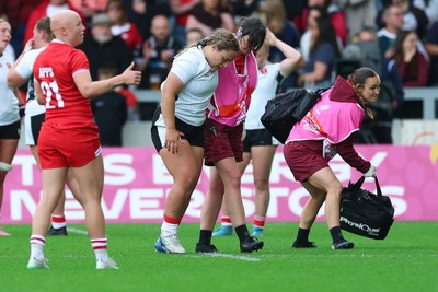 300825 - Canada v Wales, Women’s Rugby World Cup - Jenni Scoble of Wales receives treatment from Dr Gwennan Williams, Wales Women team doctor, and Cara Jones, physio before leaving the pitch with an injury