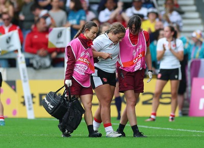 300825 - Canada v Wales, Women’s Rugby World Cup - Jenni Scoble of Wales receives treatment from Dr Gwennan Williams, Wales Women team doctor, and Cara Jones, physio before leaving the pitch with an injury