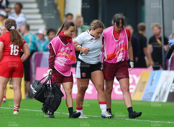 300825 - Canada v Wales, Women’s Rugby World Cup - Jenni Scoble of Wales receives treatment from Dr Gwennan Williams, Wales Women team doctor, and Cara Jones, physio before leaving the pitch with an injury