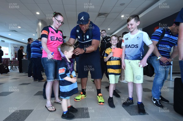 130518 - Cardiff Blues Arrival - Nick Williams lets a young fan wear his medal as he arrives at Cardiff Airport after winning the European Rugby Challenge Cup