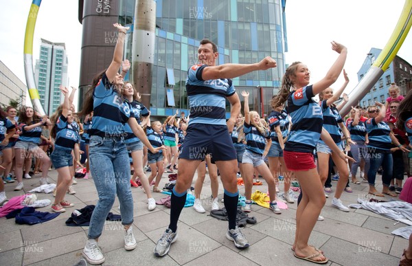 200713 - Cardiff Blues shirt launch - Cardiff Blues launch their new shirt for the 2013-14 season, with a flash mob dance routine featuring Blues player Robin Copeland outside Cardiff Library