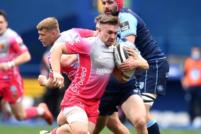 090521 - Cardiff Blues v Dragons - Guinness PRO14 Rainbow Cup - Taine Basham of Dragons is tackled by Max Llewellyn of Cardiff Blues