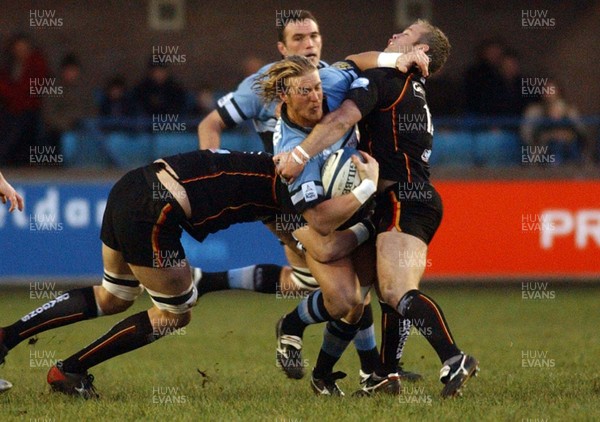 271205 - Cardiff Blues v Newport Gwent Dragons - Celtic League -  Blues' Andy Powell tries to get past Luke Charteris and Jon Bryant 