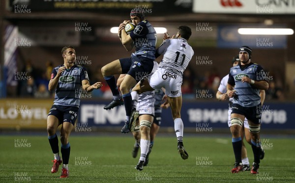 171117 - Cardiff Blues v Ospreys - Anglo Welsh Cup - Rhun Williams of Cardiff Blues gets to the ball quicker than Jay Baker of Ospreys
