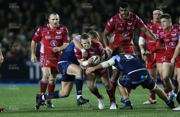 030120 - Cardiff Blues v Scarlets, Guinness PRO14 - Hadleigh Parkes of Scarlets is tackled by Scott Andrews of Cardiff Blues and Josh Navidi of Cardiff Blues