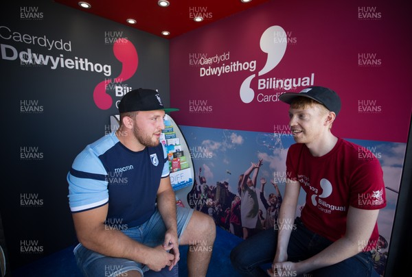 050818 - Cardiff Blues player Dillon Lewis chats with Dylan Hughes of Bilingual Cardiff at the Cardiff Council Stand at the National Eisteddfod to help announce an increased commitment by Cardiff Blues to the Welsh language as part of CardiffsBilingual Day