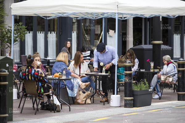 150720 - Picture shows people eating and drinking outside at a cafe in Cardiff, South Wales during the coronavirus pandemic