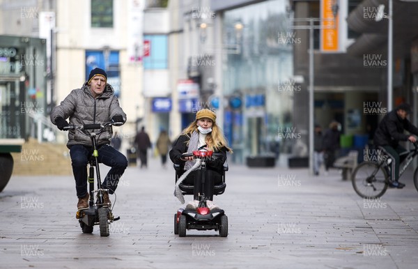 300320 - Cardiff City Centre Lockdown - Two people ride their motorised transport on The Hayes, Cardiff during the coronavirus lockdown