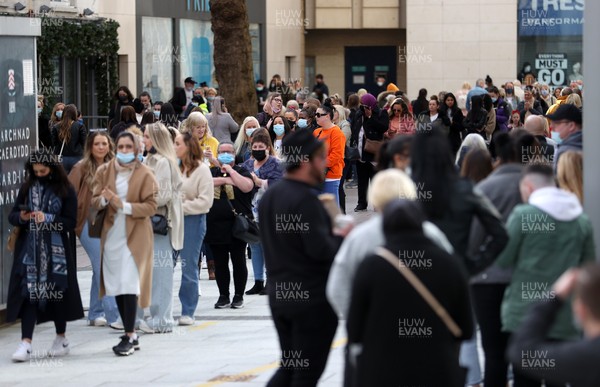 120421 - Picture shows shoppers queueing outside Primark Cardiff City Centre, Wales this morning on the first day non essential shops are allowed to be open since December 2020 during the coronavirus pandemic