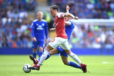 020918 - Cardiff City v Arsenal - Premier League - Mesut Ozil of Arsenal is tackled by Joe Ralls of Cardiff City