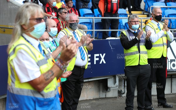 180921 - Cardiff City v Bournemouth, Sky Bet Championship - Cardiff City stewarding staff observe a round of applause in memory of fellow steward Dai Motherway who passed away recently