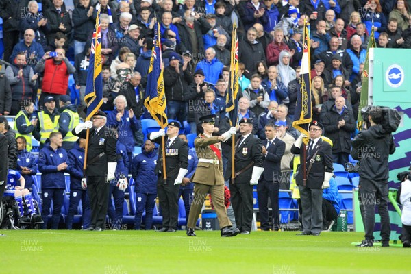101118 - Cardiff City v Brighton & Hove Albion, Premier League - A member of the Armed Forces marches past a Guard of Honour from the Royal British Legion to lay a wreath of poppies in the centre circle before the start of the match