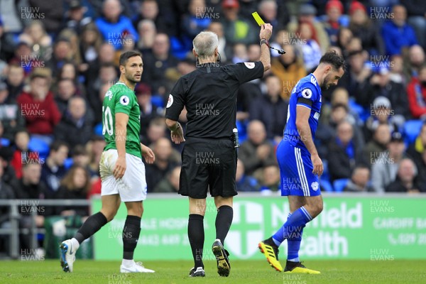101118 - Cardiff City v Brighton & Hove Albion, Premier League - Referee Martin Atkinson shows the yellow card to Greg Cunningham of Cardiff City (right)