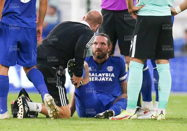 240821 - Cardiff City v Brighton and Hove Albion, EFL Carabao Cup - Sean Morrison of Cardiff City receives treatment for an injury before handing the captains armband to Aden Flint and being replaced