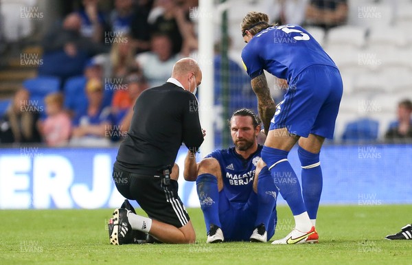 240821 - Cardiff City v Brighton and Hove Albion, EFL Carabao Cup - Sean Morrison of Cardiff City receives treatment for an injury before handing the captains armband to Aden Flint and being replaced
