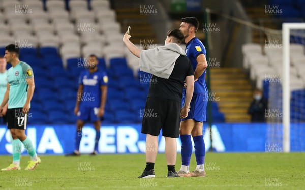 240821 - Cardiff City v Brighton and Hove Albion, EFL Carabao Cup - A Cardiff City fan invades the pitch and takes a selfie with Kieffer Moore of Cardiff City and other players before leaving the pitch