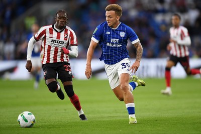 260825 - Cardiff City v Cheltenham Town - Carabao Cup Round Two - Isaak Davies of Cardiff City runs past Harrison Sohna of Cheltenham Town and scores the first goal of the game