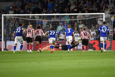 260825 - Cardiff City v Cheltenham Town - Carabao Cup Round Two - Matthew Turner of Cardiff City saves the penalty effort from Lee Angol of Cheltenham Town