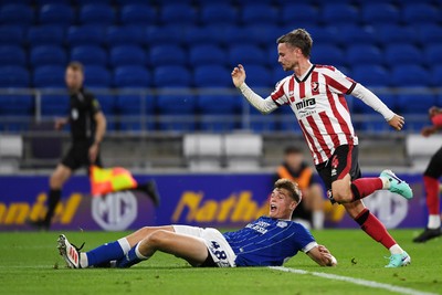 260825 - Cardiff City v Cheltenham Town - Carabao Cup Round Two - Dylan Lawlor of Cardiff City is challenged by Liam Kinsella of Cheltenham Town