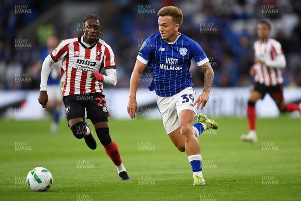 260825 - Cardiff City v Cheltenham Town - Carabao Cup Round Two - Isaak Davies of Cardiff City runs past Harrison Sohna of Cheltenham Town and scores the first goal of the game