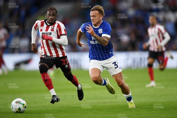 260825 - Cardiff City v Cheltenham Town - Carabao Cup Round Two - Isaak Davies of Cardiff City runs past Harrison Sohna of Cheltenham Town and scores the first goal of the game