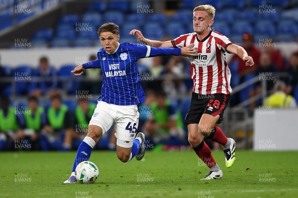 260825 - Cardiff City v Cheltenham Town - Carabao Cup Round Two - Cian Ashford of Cardiff City is challenged by Tommy Backwell of Cheltenham Town