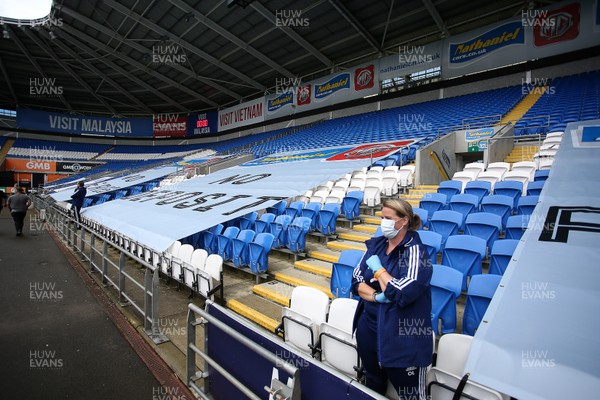 210620 - Cardiff City v Leeds United - SkyBet Championship - The empty stands with a single member of Cardiff staff wearing a face mask and gloves before kick off
