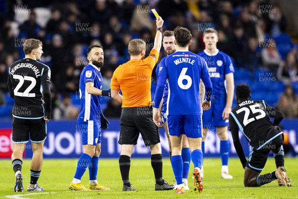 291223 - Cardiff City v Leicester City - Sky Bet Championship - Match Referee John Busby shows a yellow card to Joe Ralls of Cardiff City