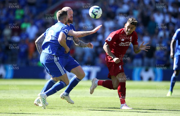 210419 - Cardiff City v Liverpool FC - Premier League - Roberto Firmino of Liverpool headers the ball away from Aron Gunnarsson of Cardiff City