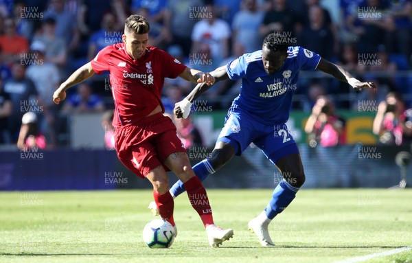 210419 - Cardiff City v Liverpool FC - Premier League - Oumar Niasse of Cardiff City is tackled by Roberto Firmino of Liverpool