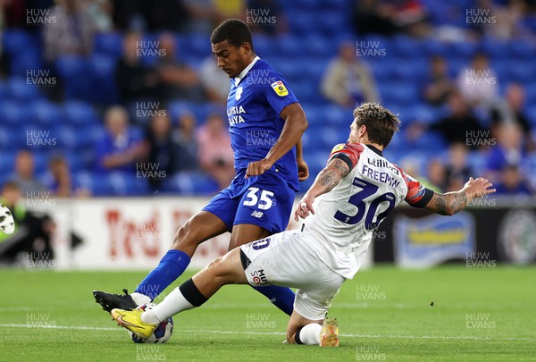 300822 - Cardiff City v Luton Town - SkyBet Championship - Andy Rinomhota of Cardiff City is tackled by Luke Freeman of Luton Town