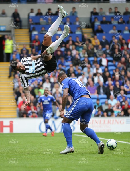 180818 - Cardiff City v Newcastle United, Premier League - Jamaal Lascelles of Newcastle United flies over the top of Kenneth Zohore of Cardiff City as he looks to win the ball