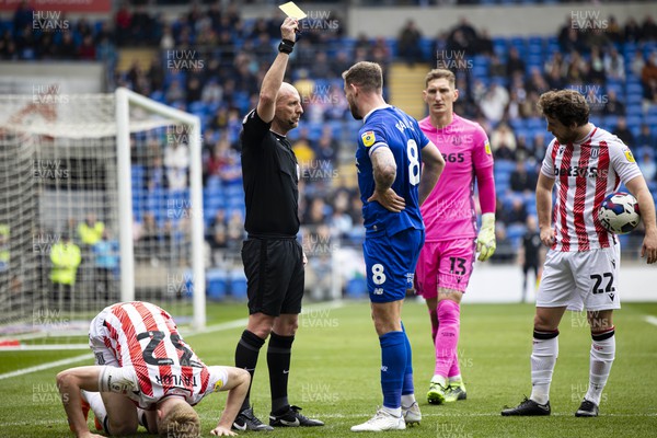 220423 - Cardiff City v Stoke City - Sky Bet Championship - Match Referee Andy Davies shows a yellow card to Joe Ralls of Cardiff City