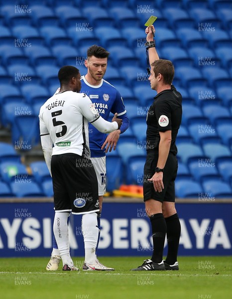 121220 - Cardiff City v Swansea City - SkyBet Championship - Marc Guehi of Swansea City and Kieffer Moore of Cardiff City both receive at yellow card from referee John Brooks